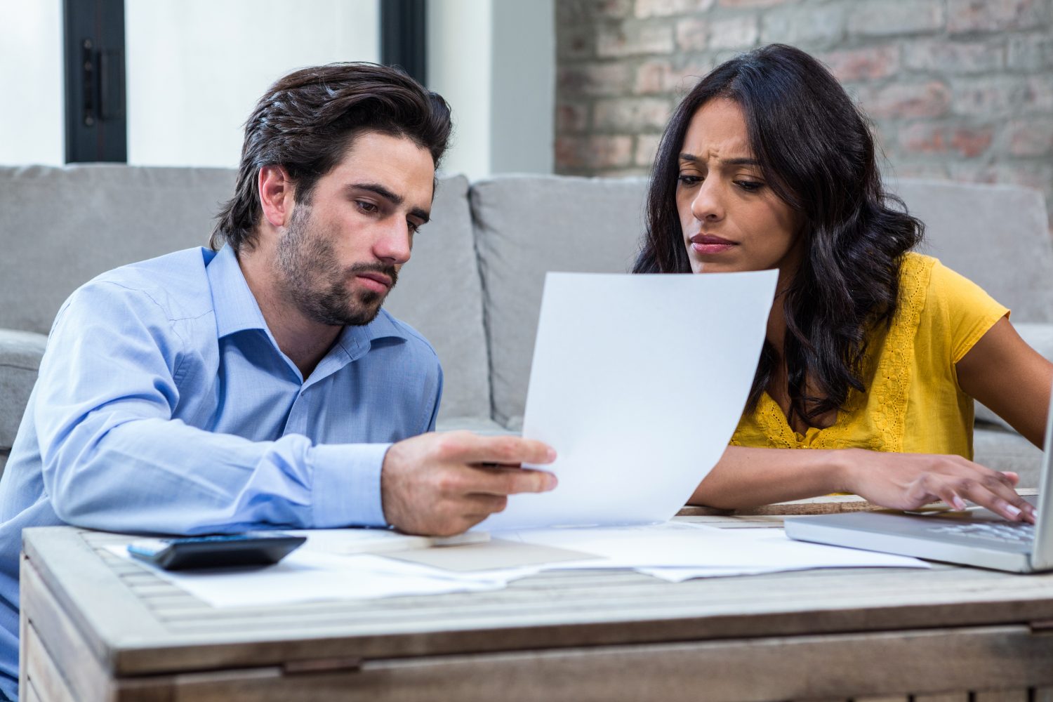 Couple sitting at a table reviewing crop insurance claim records